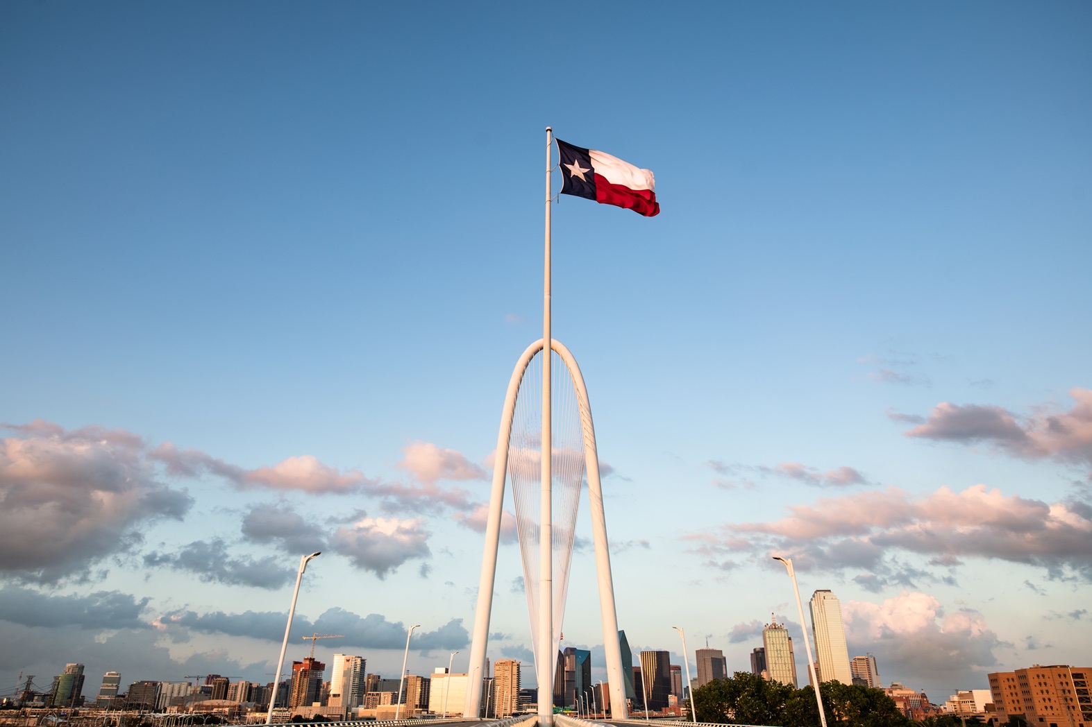 Texas flag over the Margaret Hunt Hill Bridge with Dallas skyline